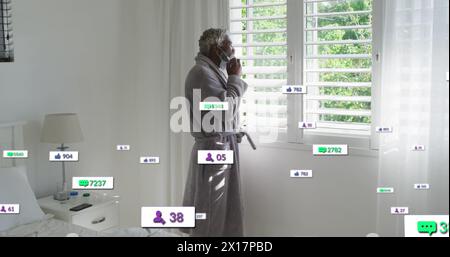 Immagine del testo dei social media e delle icone su un anziano uomo afroamericano a casa Foto Stock