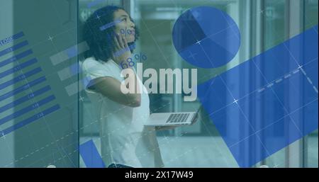Immagine dell'elaborazione di dati statistici contro una donna birazziale intelligente che utilizza un laptop in ufficio Foto Stock