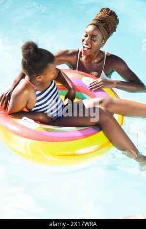Madre afroamericana che si diverte a giocare a biliardo con la sua giovane figlia a casa Foto Stock