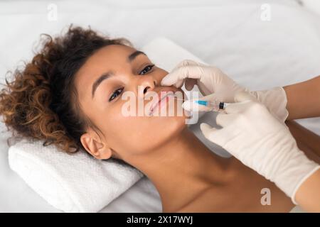 Lip augmentation. Giovane donna riceve iniezione di acido Foto Stock