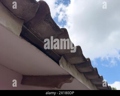 Vecchio tetto con buchi in legno da vicino su sfondo blu del cielo Foto Stock