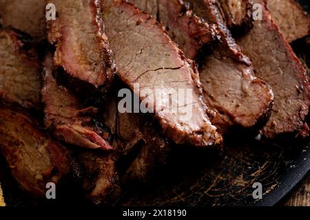 Brisket di manzo affumicato a fette sul piatto da portata con pane tostato e salsa barbecue Foto Stock