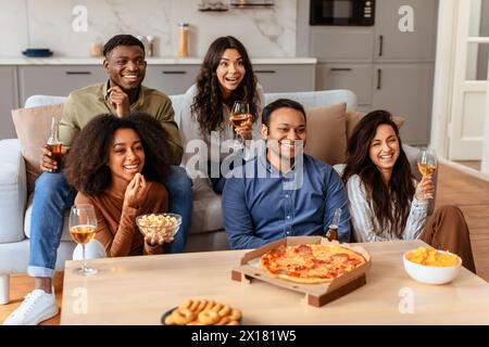 Gruppo di amici che si godono un pasto e un vino insieme Foto Stock