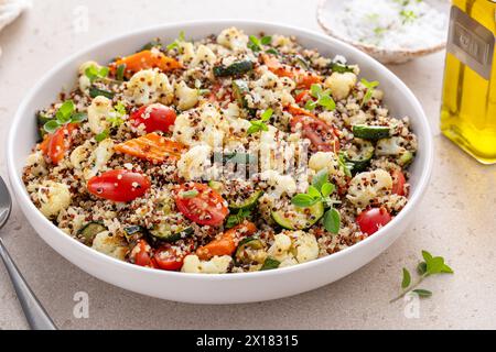 Insalata di quinoa con verdure arrostite, cavolfiore e zucchine, erbe fresche e pomodori Foto Stock