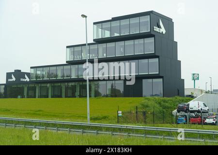 Waregem, Belgio - 22 maggio 2023: Un grande edificio nero situato sul lato di una strada, torreggiante sul paesaggio. Foto Stock