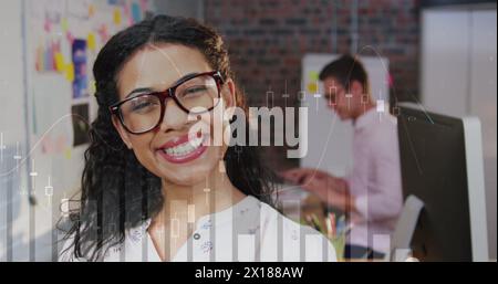 Immagine di grafici finanziari su felice donna d'affari birazziale in carica Foto Stock