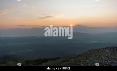 Vista del tramonto dalla cima di una montagna in estate Foto Stock