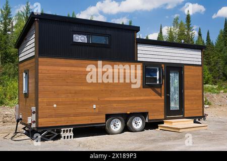 Contemporanea facciata Mini House mobile con tetto inclinato di 8 x 24 piedi, rivestita di ciottoli di legno di pino e quercia grigia color marrone e rivestita di nero Foto Stock