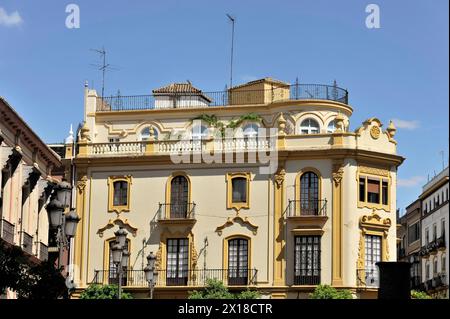 Siviglia, Un edificio storico con una facciata gialla, balconi e piante decorate, Siviglia, Andalusia, Spagna Foto Stock