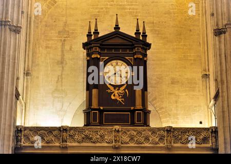 Cattedrale, Catedral de Santa Maria de la Sede con Giralda, Siviglia, un'antica torre dell'orologio con decorazioni dorate nell'alto muro di una cattedrale Foto Stock