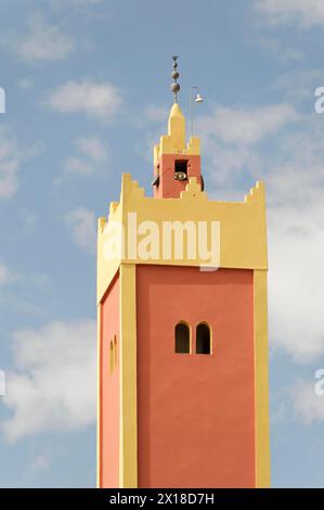 Città deserta di Rissani, colorato minareto islamico di una moschea di fronte a un cielo parzialmente nuvoloso, Medio Atlante, Marocco Foto Stock