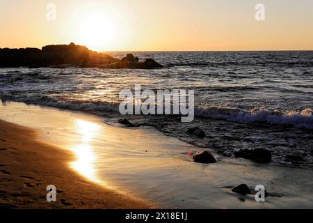 Spiaggia a Poneloya, Las Penitas, Leon, Nicaragua, il tramonto colora la spiaggia e le onde in una luce dorata, America centrale e America centrale Foto Stock