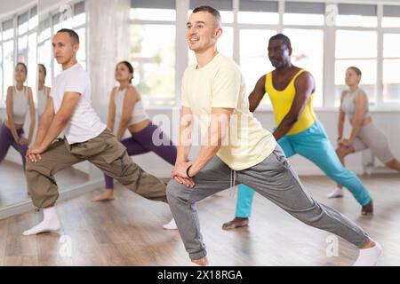 Gruppo di persone che si scaldano prima della lezione di ballo Foto Stock