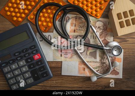 Forniture mediche e calcolatrice su tavolo di legno pile di banconote della corona ceca concetto di inflazione e di economia domestica della salute finanziaria in Cechia Foto Stock