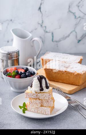 Tradizionale torta alla vaniglia a fette e servita con gelato e frutti di bosco freschi Foto Stock