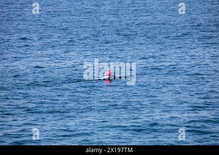 Un uomo in kayak pagaia attraverso il porto di Sydney da solo tra le teste, Sydney, Australia Foto Stock