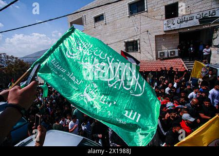 Nablus, Palestina. 15 aprile 2024. I lutti hanno visto sventolare le bandiere di Hamas durante il funerale dell'adolescente palestinese Yazan Muhammad Fawzi Shtayyeh, 17 anni, che è stato ucciso dalle forze israeliane durante un raid per arrestare persone ricercate, nella città di Nablus, nella Cisgiordania occupata a nord. Shtayyeh è uno studente della scuola industriale con sogni di successo ed eccellenza nel futuro. Credito: SOPA Images Limited/Alamy Live News Foto Stock