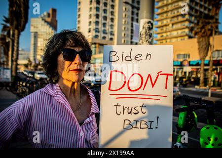 Tel Aviv, Israele. 15 aprile 2024. Un manifestante ha un cartello che chiede al presidente degli Stati Uniti Joe Biden di non fidarsi del primo ministro israeliano Benjamin Netanyahu durante una manifestazione. Israele ha promesso di "determinare un prezzo” dall'Iran dopo un attacco senza precedenti su larga scala con drone e missili nel fine settimana che ha intensificato le tensioni regionali innescate dalla guerra a Gaza. (Foto di Eyal Warshavsky/ SOPA Images/Sipa USA) credito: SIPA USA/Alamy Live News Foto Stock