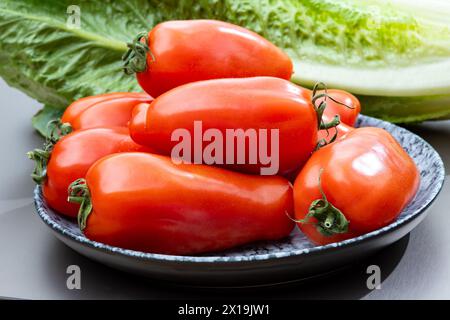 Pomodori lunghi rossi maturi italiani san marzano in tavola Foto Stock