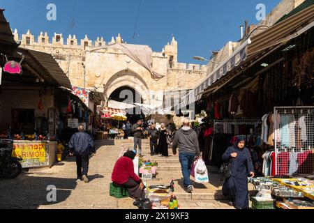 Gerusalemme, Israele - 24 febbraio 2023: Le persone fanno shopping e passeggiano nel quartiere musulmano di fronte alla porta di Damsco nella città vecchia di Gerusalemme. Foto Stock