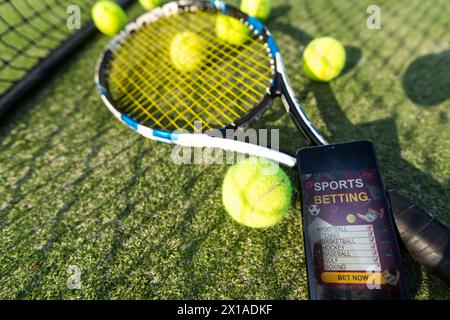 Palla con racchetta rossa appoggiata su rete da tennis in campo durante la giornata di sole. Concetto di gioco inalterato, sportivo e tennis. Foto Stock