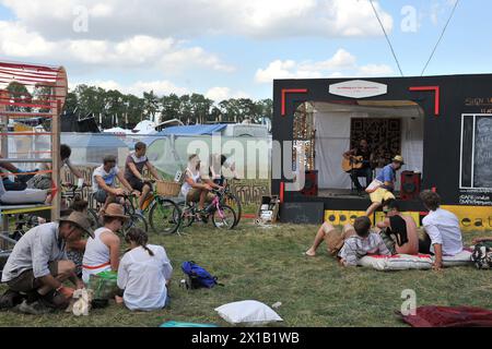 Un artista canta su un piccolo palco alimentato da biciclette durante il WOMAD festival 2013, che si tiene a Charlton Park, Wiltshire. Foto Stock