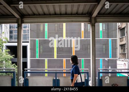 Pedoni che camminano lungo una passerella sopraelevata presso la stazione BTS sala Daeng nella zona Silom di Bangkok, Thailandia. Foto Stock