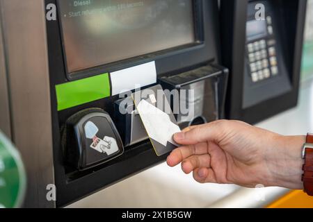 Vista ravvicinata dell'uomo che paga il carburante con una carta di credito sul terminal della stazione di servizio self-service in Europa Foto Stock