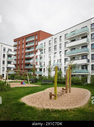 Amburgo, Germania. 16 aprile 2024. Vista sul cortile interno di un nuovo complesso residenziale con spazio verde e parco giochi per bambini nel parco cittadino. Credito: Christian Charisius/dpa/Alamy Live News Foto Stock