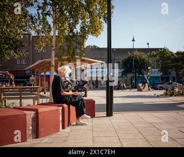 Mercato di Bermondsey, disposizione dei posti a sedere pubblici in uso, con area coperta, alberi e negozi di alta moda sullo sfondo. The Blue, Londra, Regno Unito. Foto Stock