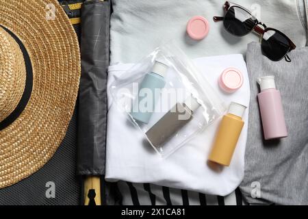 Kit cosmetico da viaggio, sacchetto di plastica e accessori in valigia, vista dall'alto Foto Stock