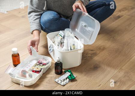 Donna che mette il medicamento nel kit di pronto soccorso in casa, primo piano. Spazio per il testo Foto Stock