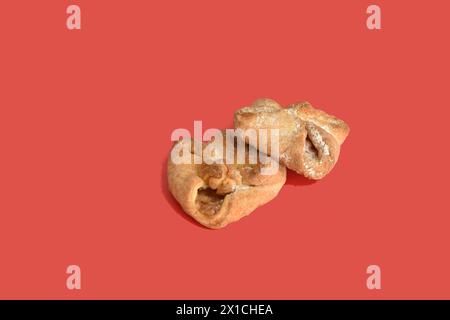 Diversi biscotti pieni di forma quadrata giacciono su sfondo rosso. Foto Stock