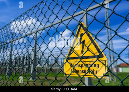 Gelbes Warnschild mit der Aufschrift Hochspannung Lebensgefahr an einem Zaun vom Avacon Umspannwerk Helmstedt Helmstedt Niedersachsen Deutschland *** cartello di avvertimento giallo con le parole pericolo alta tensione per la vita su una recinzione della sottostazione di Avacon Helmstedt Helmstedt bassa Sassonia Germania Foto Stock