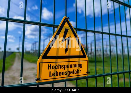 Gelbes Warnschild mit der Aufschrift Hochspannung Lebensgefahr an einem Zaun vom Avacon Umspannwerk Helmstedt Helmstedt Niedersachsen Deutschland *** cartello di avvertimento giallo con le parole pericolo alta tensione per la vita su una recinzione della sottostazione di Avacon Helmstedt Helmstedt bassa Sassonia Germania Foto Stock