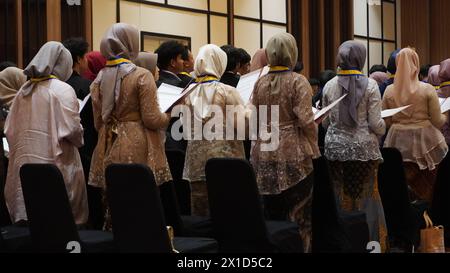 Studenti delle scuole superiori in piedi mentre leggono l'impegno degli ex studenti durante la cerimonia di laurea Foto Stock