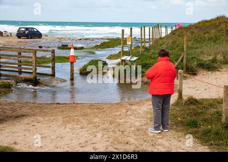 Porthtowan, Cornovaglia, 16 aprile 2024, la gente era fuori per una passeggiata mattutina sulla spiaggia con l'alta marea a Porthtowan, Cornovaglia. C'era un po' di inondazione dal torrente che sfocia sulla spiaggia. Il cielo era blu con un sole glorioso e 10C, le previsioni dopo oggi sono variabili per i prossimi giorni. Crediti: Keith Larby/Alamy Live News Foto Stock