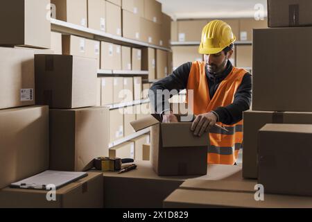 Magazziniere che prepara un pacchetto per il concetto di spedizione, logistica e commercio Foto Stock