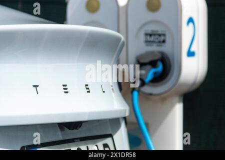 Veicolo a marchio Tesla che ricarica le batterie presso un punto di ricarica o una stazione elettrica in una giornata di sole nella città di Lisbona Foto Stock