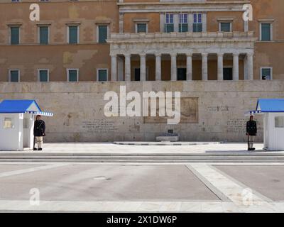 Gli Evzones, la guardia presidenziale, fanno la guardia fuori dal vecchio Palazzo reale che ora funge da edificio del Parlamento greco ad Atene, in Grecia Foto Stock