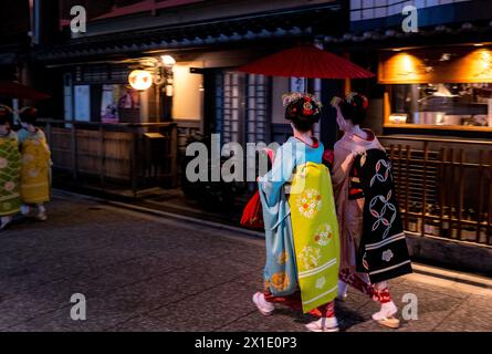 Giappone - Geisha tornano a casa in serata nel quartiere dei divertimenti di Kyoto indossando kimono tradizionali Foto Stock