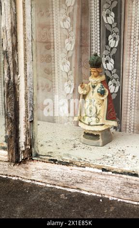 Statua del bambino di Praga nella finestra di un cottage abbandonato sulla Wild Atlantic Way a Donegal in Irlanda Europa Foto Stock