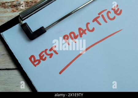 Concetto di BEST practice scrivere su documenti cartacei isolati su sfondo in legno. Foto Stock