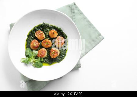 Deliziose capesante fritte con salsa gustosa e insalata di mais nel recipiente sul tavolo bianco, vista dall'alto. Spazio per il testo Foto Stock