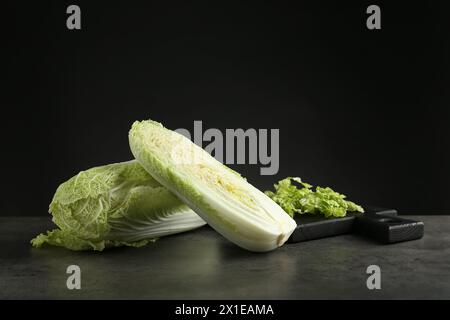 Intere e tagliare i cavoli cinesi freschi su un tavolo grigio Foto Stock