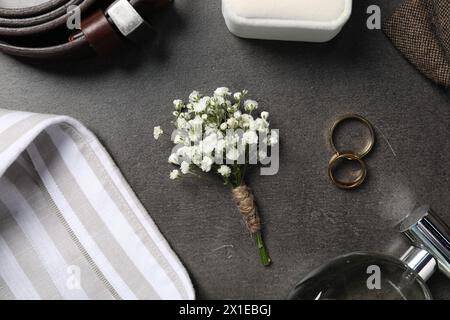 Roba per matrimoni. Composizione piatta con elegante boutonniere sul tavolo nero Foto Stock