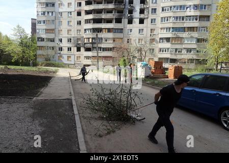 Non esclusiva: CHARKIV, UCRAINA - 13 APRILE 2024 - le persone puliscono il territorio dai blocchi di appartamenti a Charkiv, Ucraina nord-orientale. Foto Stock