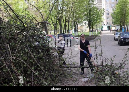 Non esclusiva: CHARKIV, UCRAINA - 13 APRILE 2024 - le persone puliscono il territorio dai blocchi di appartamenti a Charkiv, Ucraina nord-orientale. Foto Stock