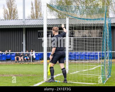 Un addetto alla linea controlla l'attacco delle reti all'inizio di una partita di calcio non di campionato Foto Stock