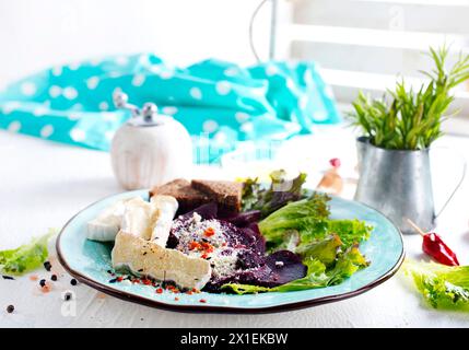 Camambrato, insalata di barbabietole e pane su piatto blu Foto Stock